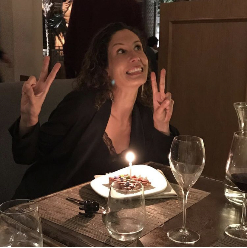 Yvonne haciendo el signo de la V delante de una vela