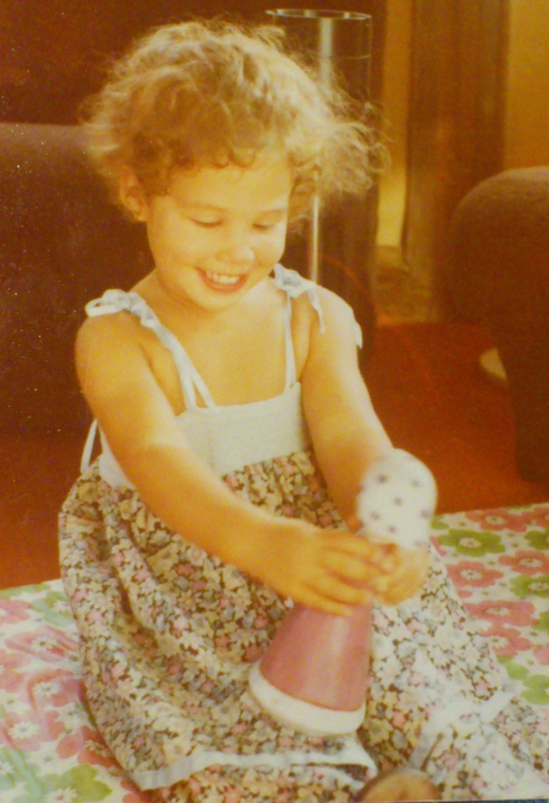 Yvonne de niña con vestido de flores jugando